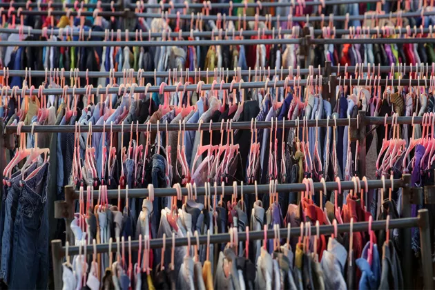 Clothes on plastic hangers on racks