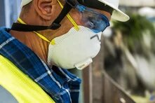 A man wearing a safety mask and protective glasses, ensuring safety while working in a hazardous environment.